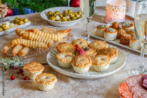 Christmas party, a selection of gourmet snacks and champagne set on a table. Selective focus