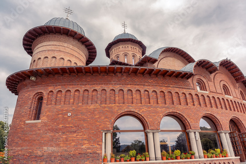 Close view of red brick cathedral facade at Curtea de Arges Monastery in Arges County, Romania