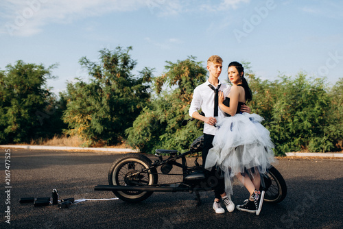 Konstfotografi A couple of newlywed freaks on a black custom bike