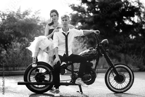 Konstfotografi A couple of newlywed freaks on a black custom bike