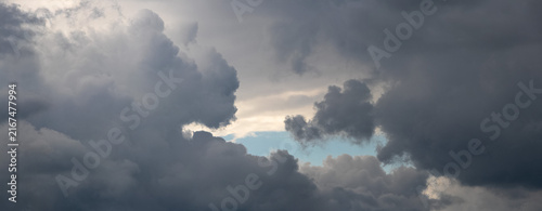 Massive storm clouds with glimpse of blue sky between them
