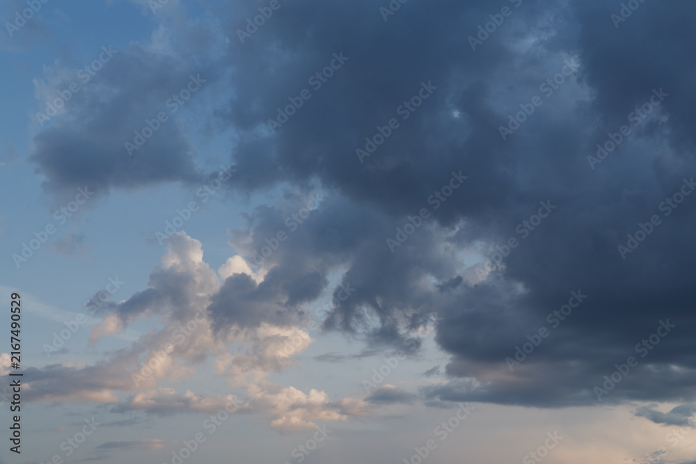 Obraz premium Dark storm clouds dramatic sunset sky background, heavy overcast cumulus cloudscape before rain, moody evening weather forecast backdrop, threatening cyclone danger conceptual nature wallpaper. 
