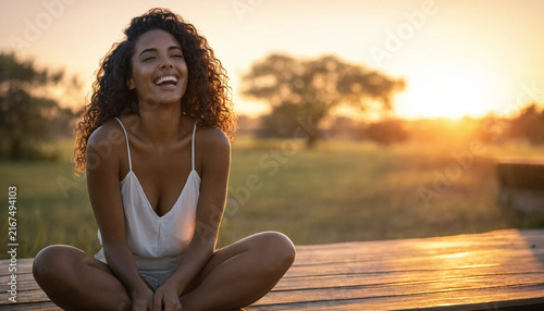Happy young African Black woman laughing outdoors at sunset during golden hour relaxed lifestyle and mental wellness concept