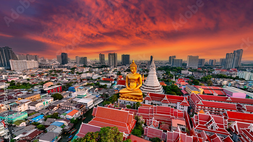 Photography Spectacular aerial view of the giant golden Buddha statue and stupa at Wat Paknam Bhasicharoen with dramatic sky and sunbeams in Thailand