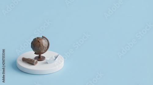 Miniature Vintage Globe on White Pedestal Against Soft Blue Background