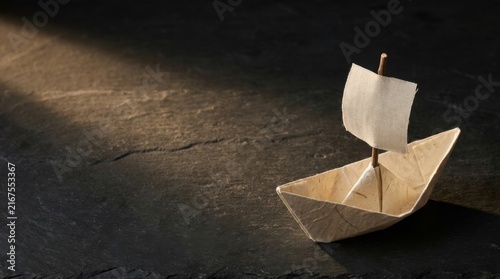 Origami Sailboat Under Spotlight on Dark Background for Journey Concept