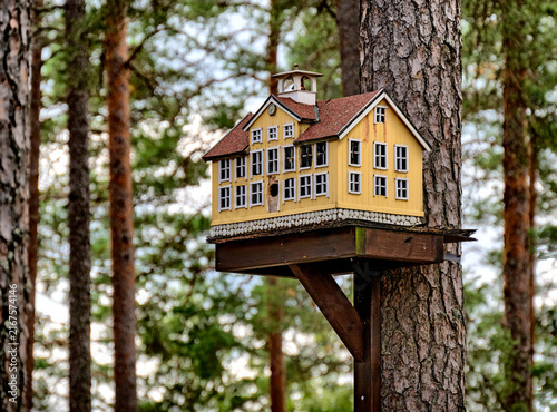 Birdhouse shaped like a traditional swedish building mounted on a tree near filmbyn smaland in Sweden