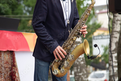 Принти на полотні A male saxophonist is playing the saxophone on the city street.