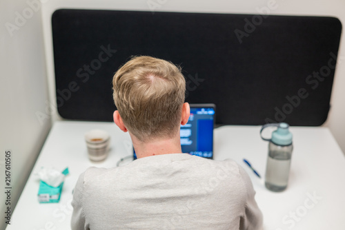 Rear view of young man working on laptop