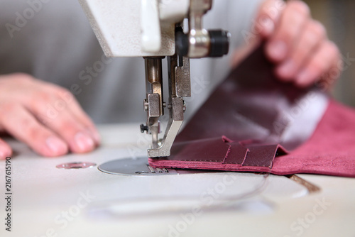Fotografie Sewing burgundy leather on an industrial sewing machine