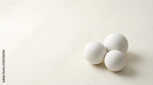 Three white eggs stacked on minimalist white background for clean product photography