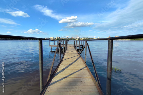 Fotografie Empty wooden pier with a sky and calm water