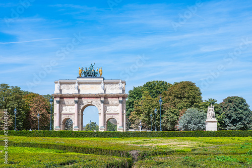 Visitors gather near the Axe Historique (historical axis) in Paris, France, during summer with clear skies and green gardens all around