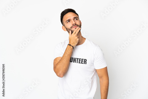 Canvastavla Young caucasian volunteer man isolated on white background having doubts
