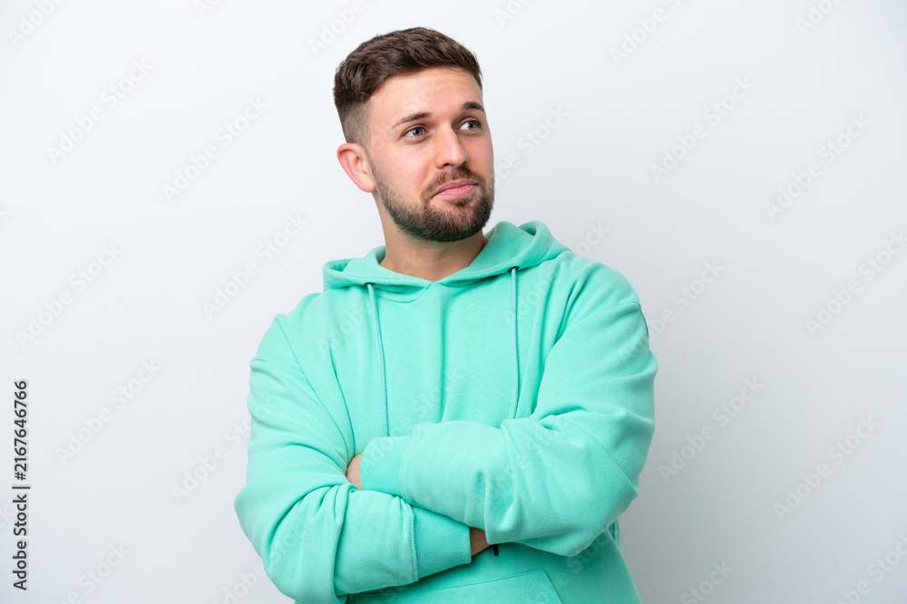 Obraz premium Young caucasian man isolated on white background making doubts gesture while lifting the shoulders