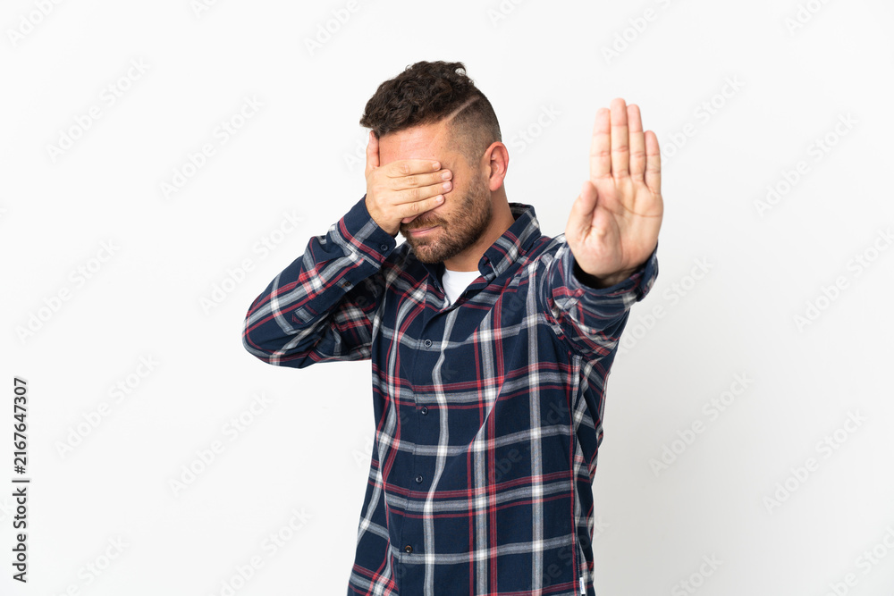 Naklejka premium Caucasian man isolated on white background making stop gesture and covering face