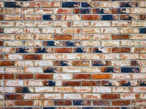Red, grey brick wall texture. Some bricks paint at black. Creative background for advertising. Top view.
