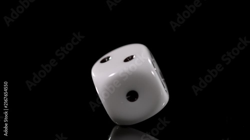 Slow motion of a die rolling and tumbling on a surface displaying detailed movement and cinematic motion
