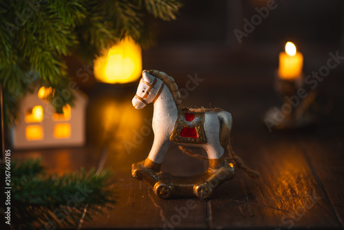 Fotografie Rocking horse miniature toy decorating a festive christmas scene on a wooden tab