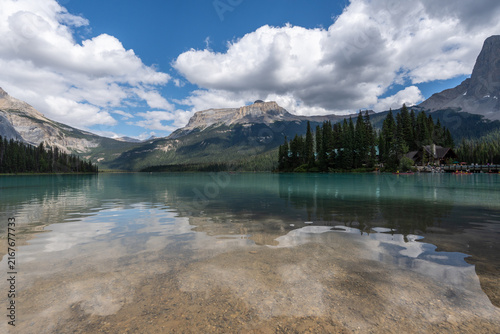 Emerald Lake in Yoho National Park, Canada, with vivid turquoise water framed by dense forest and dramatic Rocky Mountains on a summer day.