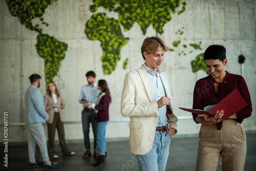 Business people collaborating in office with global map