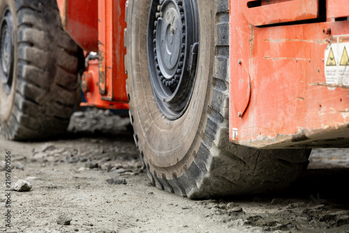 Obraz na plátně Heavy-duty tunnel dump truck wheels on rough terrain, showcasing robust tread pa