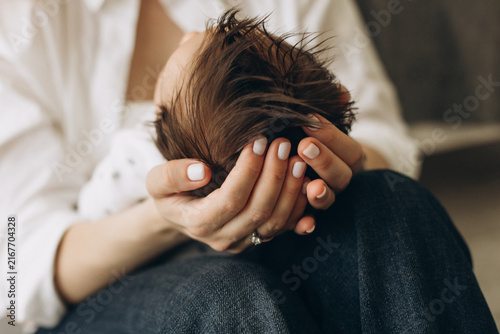 Fotografie Tender Embrace: A mother cradles her newborn's delicate head in her hands, a portrait of maternal love and the precious beginnings of life