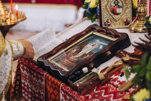 Foto Sacred Altar of Orthodoxy: A richly decorated altar displays religious icons, a holy book, and a crucifix, set within a solemn place of worship, illuminated by candlelight
