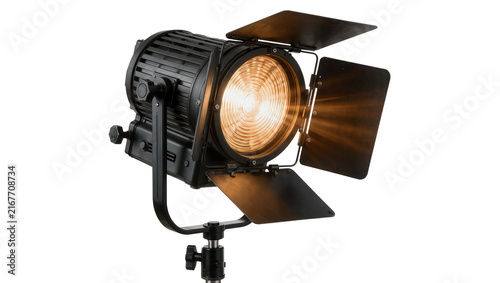 Bild auf Leinwand Professional black Fresnel spotlight with barn doors, emitting warm light isolat