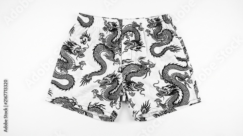 White boxer shorts with a black and grey dragon pattern laid flat on a white background.