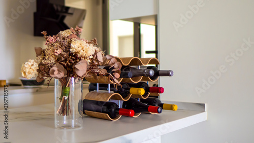 Wine bottles on a special stand in the kitchen. Blurred background.