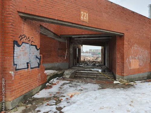 An abandoned red brick building entrance marked with the number 