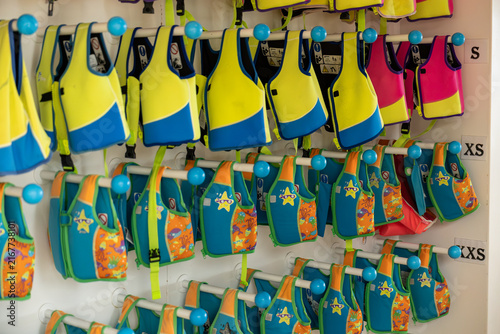 Foto Colorful life jackets arranged by size on storage racks aboard a passenger cruis