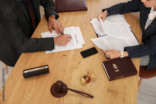 Fotografía Lawyers working with papers during meeting at table in office, top view