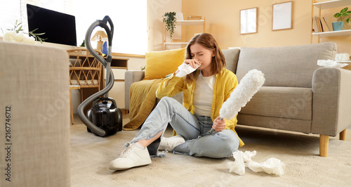 Принти на полотні Allergy and dust sensitivity, young woman sneezing while cleaning home, seasonal