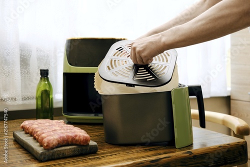 Placing parchment paper under crisper tray of air fryer basket to ensure proper circulation of hot air while cooking food