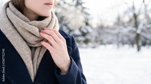 Obraz na płótnie 雪景色の中でマフラーを整える女性