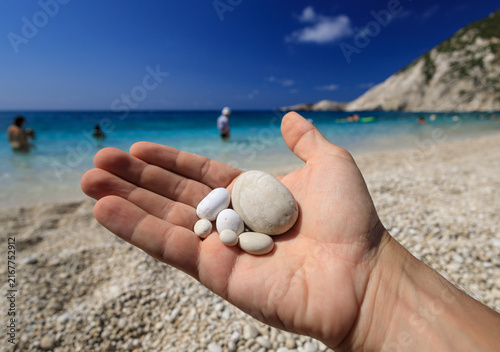Detail - Pebbles in hand on Petani Beach, one of the most beautiful beaches in Europe