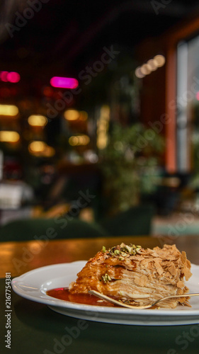 Foto Delicious mille-feuille pastry with caramel sauce and pistachios on a plate