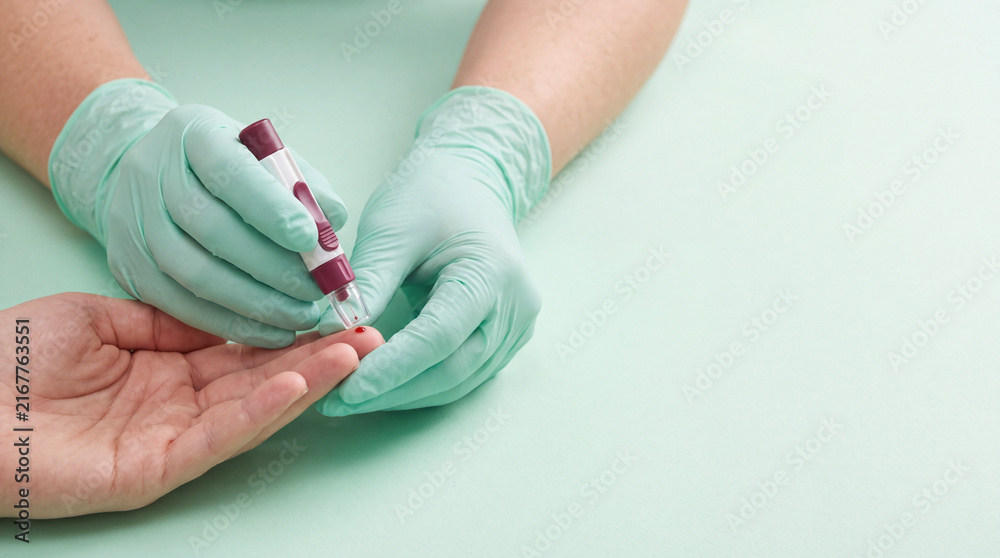 Fototapeta premium blood donation medical professional using lancet device for finger prick test in clinic