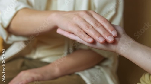 Reiki energy healing session hands transferring energy. Close-up of a reiki practitioner's hands performing an energy healing session by channeling ki energy to the patient's palm