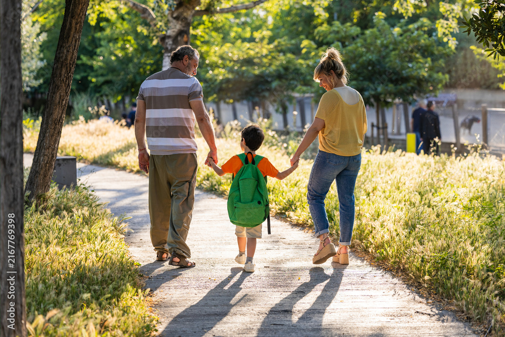 Fototapeta premium Three generations family walking child to school