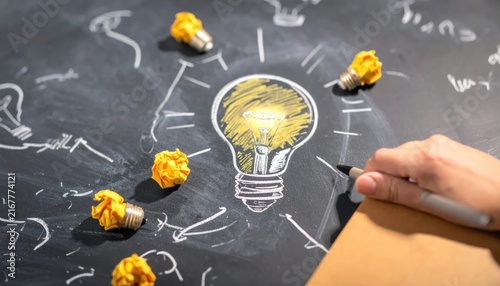 Obraz na płótnie Creative idea generation concept with light bulb drawing on chalkboard.