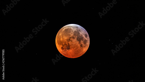 A full moon appearing red during partial lunar eclipse.