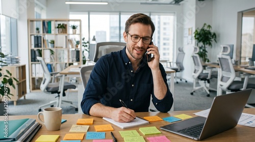 Professional man working in modern office with sticky notes and laptop on desk