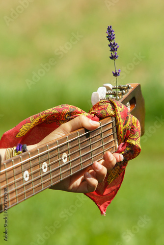 Obraz na płótnie Closeup of hand tuning acoustic guitar headstock with fabric tied and lavender s