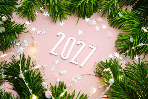 New Year 2027 pink background. Number of the coming year in Christmas decoration.
