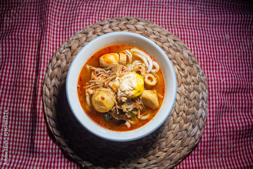 Photography Top View Flat Lay of Spicy Asian Noodle Soup with Fish Balls, Egg, and Enoki Mus