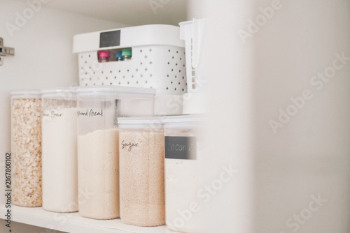 фотографія Pantry organization, kitchen storage, food containers, home organization, kitchen cabinet, clear canisters, decluttering solutions for a neat modern home interior with labels