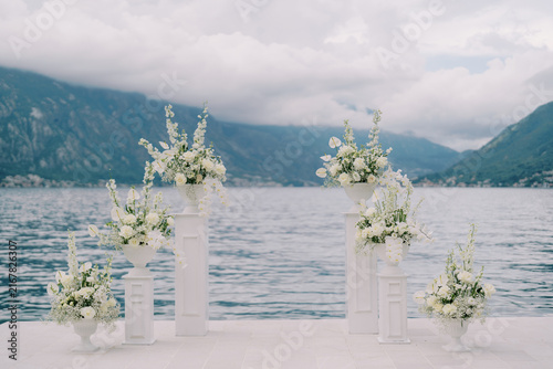 Elegant wedding arch with white flowers on Kotor Bay pier